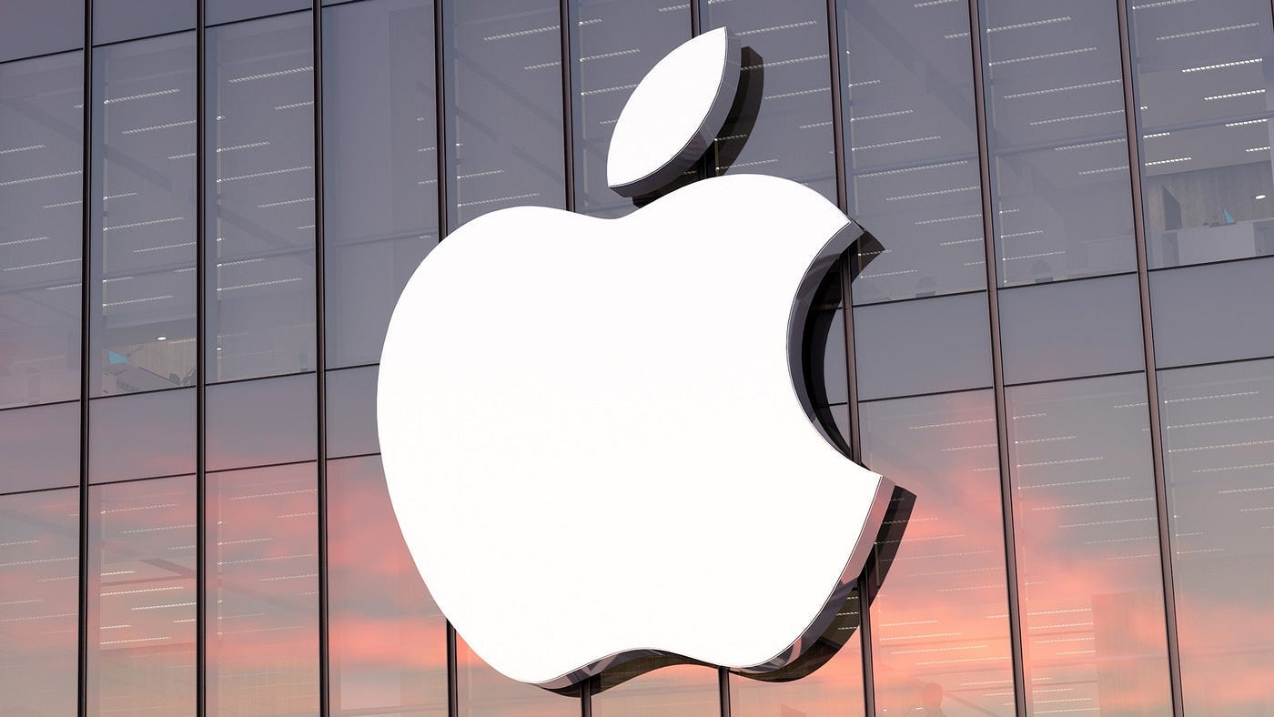 Camlı bir binanın cephesindeki büyük beyaz Apple logosunun yakın çekimi.