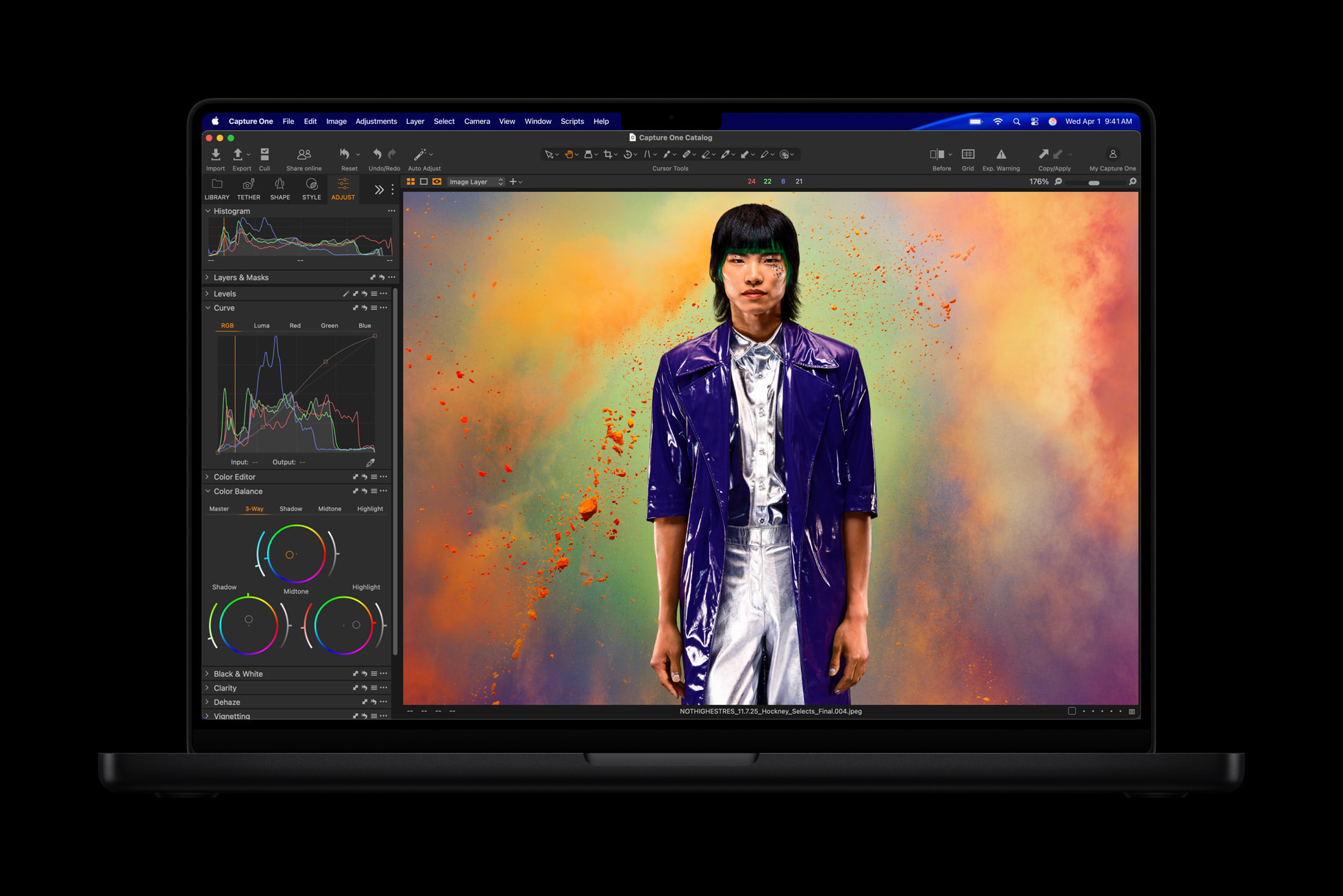Bir MacBook Pro ekranında fotoğraf düzenleme yazılımı açık; ortada renkli arka planlı bir portre var.